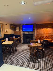 a restaurant with tables and chairs and a flat screen tv at The Turf Hotel in Richmond