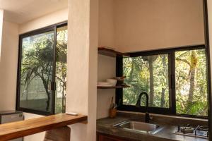 a kitchen with a sink and a window at La Punta SurfHouse in Brisas de Zicatela +15 photos