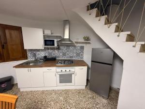 a kitchen with white cabinets and a stove and a staircase at El Molino de Valverde in Elche +13 photos