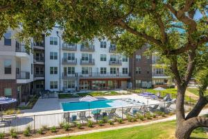 an image of an apartment building with a swimming pool at Landing Beautiful Studio Gym Pool in Addison