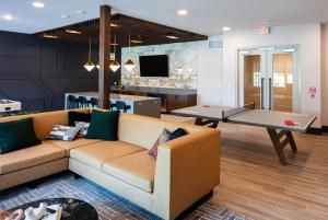 a living room with a couch and a table at Landing Beautiful Studio Gym Pool in Addison