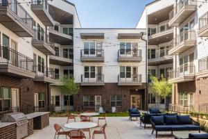 a courtyard with tables and chairs in front of a building at Landing Beautiful Studio Gym Pool in Addison