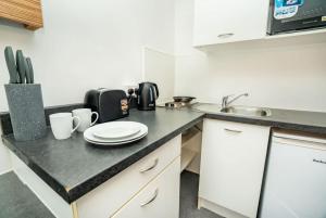 a kitchen with a counter top with a sink at Spacious & Bright Central Coventry Budget Studio in Coventry +16 photos