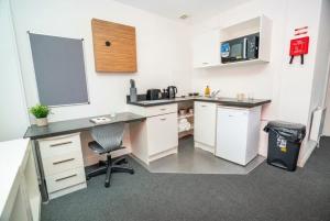 a kitchen with a desk and a chair in a room at Spacious & Bright Central Coventry Budget Studio in Coventry