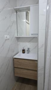 a white bathroom with a sink and a mirror at Studio apartman Milla in Karlovac +18 photos