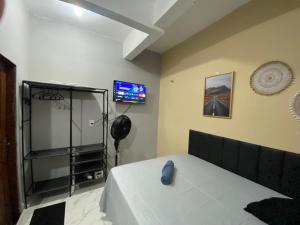 a bedroom with a bed and a television on the wall at Espaço completo no Umarizal centro de Belém in Belém