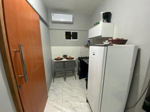 a small kitchen with a refrigerator and a table at Espaço completo no Umarizal centro de Belém in Belém