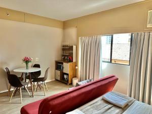 a living room with a red couch and a table at Flat Borges Lagoa com vaga de garagem, UH412 in São Paulo