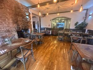 an empty restaurant with wooden tables and chairs at Manor Inn Galmpton in Brixham