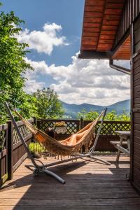 a hammock on a deck with a view of the mountains at Alemiło - uroczy dom z balią i widokiem na Babią Górę in Zawoja