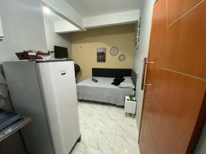a small room with a bed and a refrigerator at Espaço completo no Umarizal centro de Belém in Belém