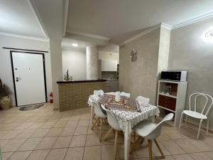 a dining room with a table and white chairs at Sikelia in Santa Elisabetta
