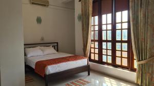 a bedroom with a bed and a large window at Oceanway Residences in Wattala