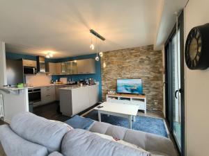 a living room with a couch and a kitchen at Spacious Quiet Pyrenees View Garage in Pau