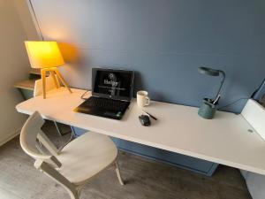 a laptop computer sitting on a white desk with a chair at Spacious Quiet Pyrenees View Garage in Pau +12 photos