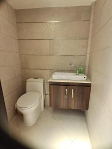 a bathroom with a toilet and a sink at Casa completa con piscina privada en Manta, Ecuador in Manta