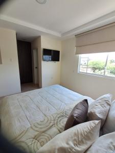a bedroom with a large bed and a television at Casa completa con piscina privada en Manta, Ecuador in Manta