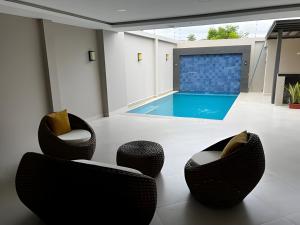 a living room with two chairs and a swimming pool at Casa completa con piscina privada en Manta, Ecuador in Manta