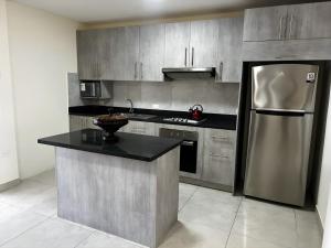 a kitchen with a stainless steel refrigerator and a counter at Casa completa con piscina privada en Manta, Ecuador in Manta