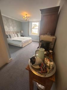 a bedroom with a bed and a table with a plate of food at Manor Inn Galmpton in Brixham