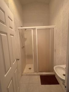 a bathroom with a shower with a glass door at Refugio de mar y arena in Acapulco +17 photos
