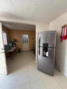 a kitchen with a stainless steel refrigerator in a room at Refugio de mar y arena in Acapulco
