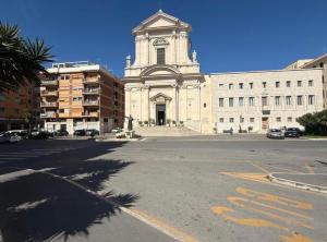 a large white building with a clock tower on a street at Emy Suites in Civitavecchia