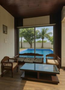 a living room with a table and two chairs and a pool at The Casa Bella in Faridabad