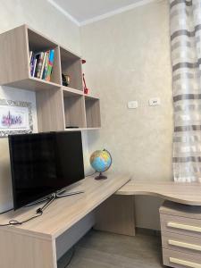 a desk with a television and a globe on it at Casa RAFAEL & GINEVRA in Stazzano