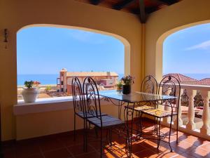 a balcony with a table and chairs and a view of the ocean at Casa Chalet El Bucanero Morro Jable in Morro del Jable