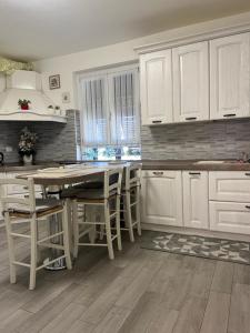 a kitchen with white cabinets and a table and chairs at Casa RAFAEL & GINEVRA in Stazzano