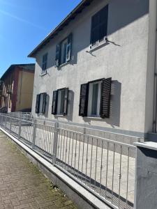 a white building with black windows and a fence at Casa RAFAEL & GINEVRA in Stazzano