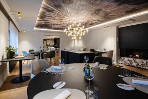 a restaurant with a table and chairs and a chandelier at Manoir Kasselslay in Roder
