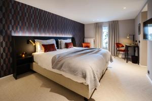 a bedroom with a large bed and a desk at Manoir Kasselslay in Roder