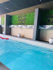 a pool with a green wall and a swimming pool at 2020 Apartment Guzape in Chini