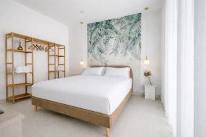 a bedroom with a white bed and a painting on the wall at TerrAmare Suites in Baronissi