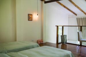 a room with two beds and a chair in it at Utopia Hostel in Ngermid
