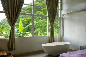 a bathroom with a tub in front of a window at Utopia Hostel in Ngermid +94 photos