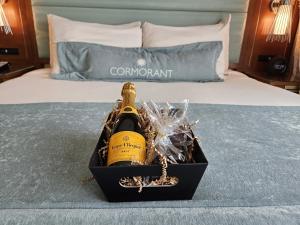 a bottle of champagne in a box on a bed at Cormorant Boutique Hotel in San Diego