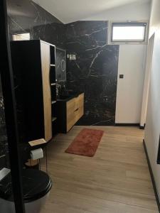 a bathroom with a black marble wall at chez Jess chambre d'hôte a UZES in Uzès
