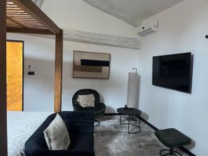 a bedroom with a bed and a tv and a chair at chez Jess chambre d'hôte a UZES in Uzès