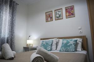 a bedroom with a bed with blue and white pillows at Helia Apartment 1 in Alepou