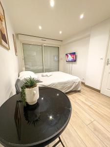 a bedroom with a bed and a table and a tv at Studio - Centre Ville in Sartrouville