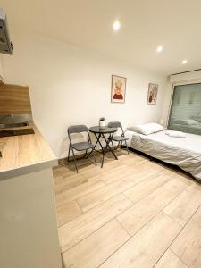 a bedroom with a bed and a table and chairs at Studio - Centre Ville in Sartrouville