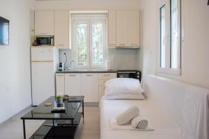 a small white kitchen with a bed and a table at Helia Apartment 1 in Alepou