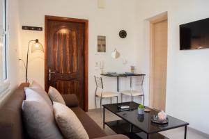 a living room with a couch and a table at Helia Apartment 1 in Alepou +6 photos