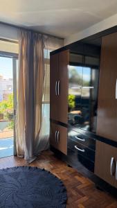 a living room with a large entertainment center with a window at Pousada da Salete in Campo Mourão +24 photos