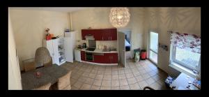 a kitchen with red cabinets and a tiled floor at Pension am Markt Luckenwalde in Luckenwalde