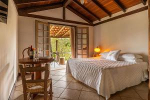 a bedroom with a bed and a table and a window at Jardim da Amazônia Lodge in Sao Jose do Rio Claro