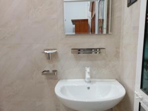 a bathroom with a white sink and a mirror at East villa in Kalmunai